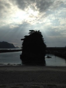 朝日を浴びる海岸に突き出た岩